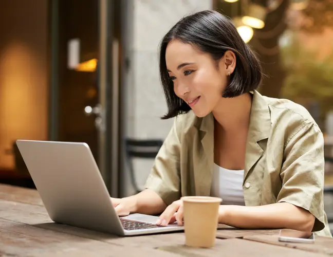 ノートパソコンを使ってカフェで仕事をする女性