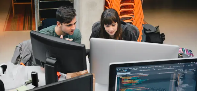 コンピューターを使って共に仕事をしている男性と女性